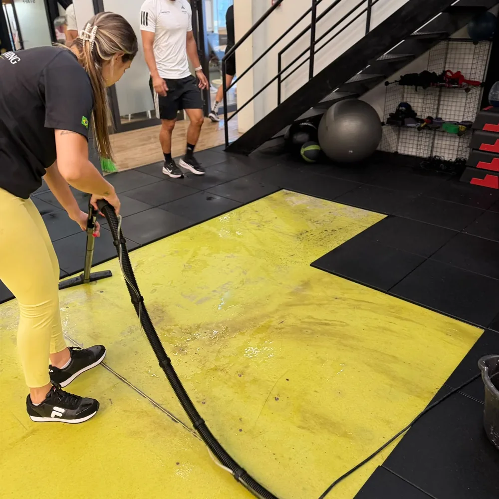Profissional da Gold Cleaning a lavar o pavimento de um ginásio