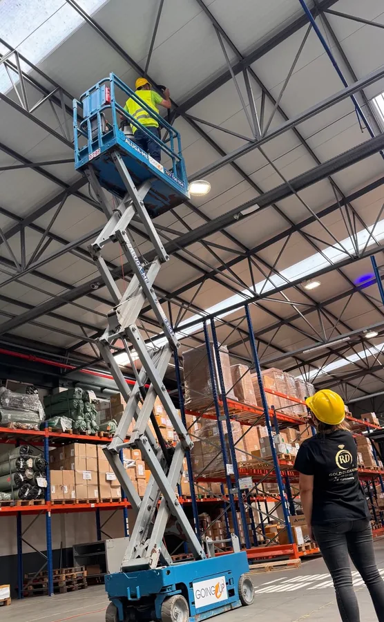 Plataforma elevatória de tesoura numa nave industrial durante a limpeza geral
