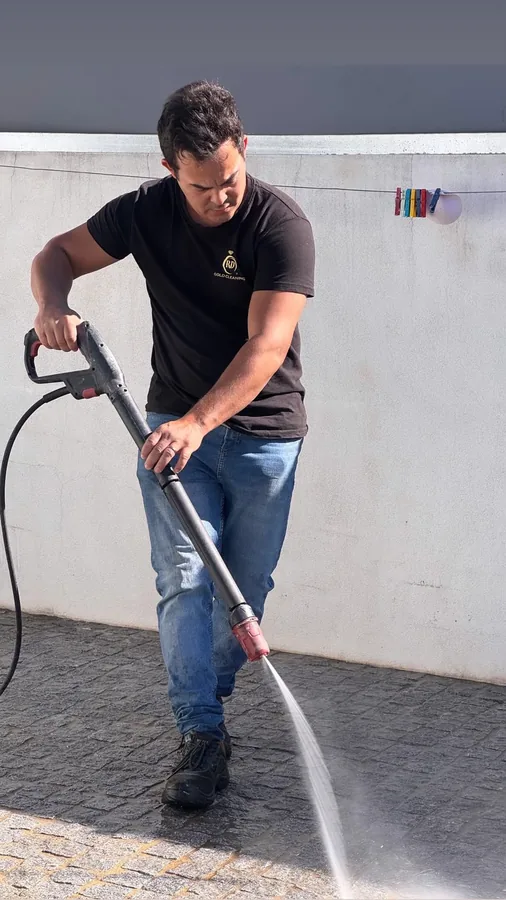 Profissional da Gold Cleaning a lavar um passeio de calçada com máquina de alta pressão